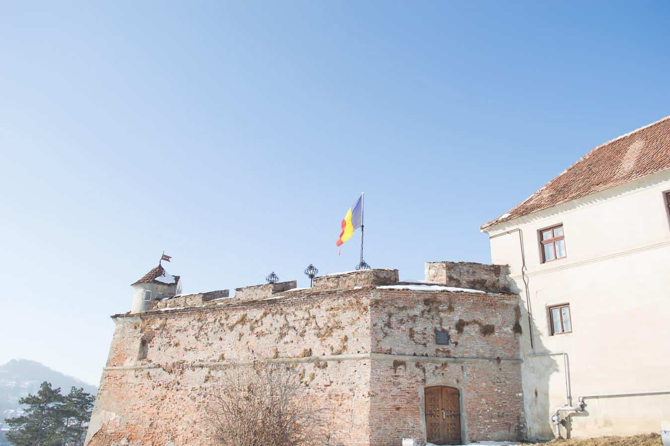 A flag waves in the wind attached to a fort.