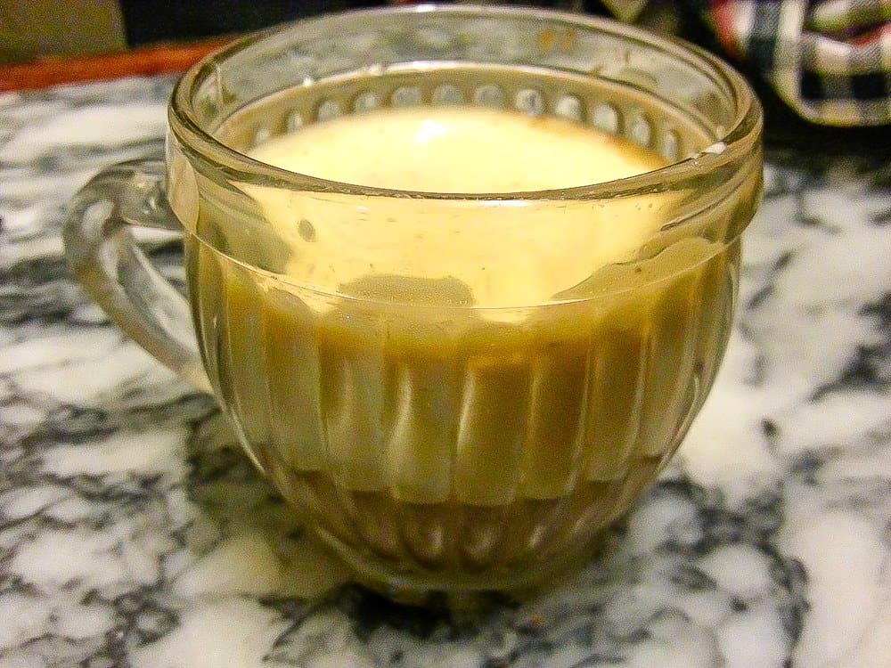 A close up of coffee in a clear mug.