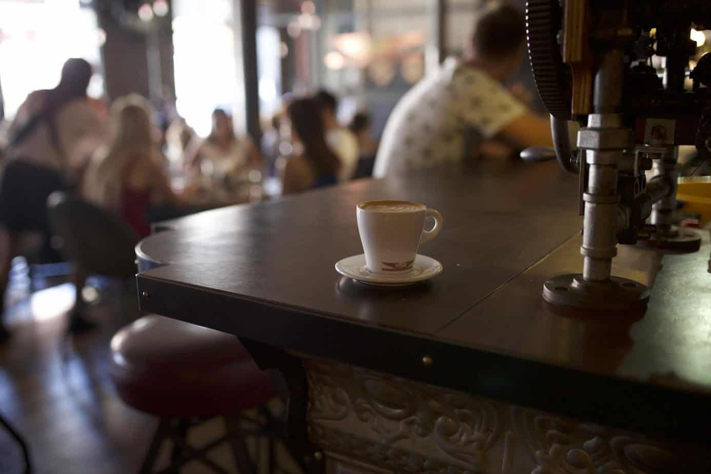 A coffee cup sits on a wooden table.