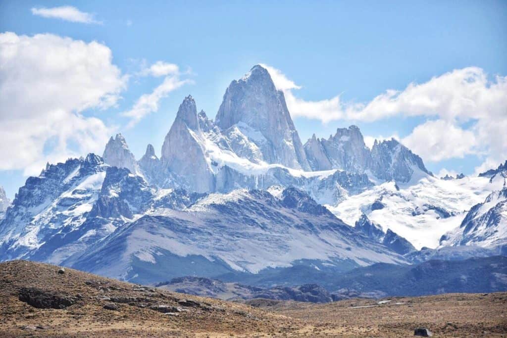 A tall mountain with snow under a undecorous sky.