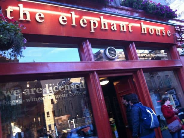 People walk into a building that\'s red that says \"The Elephant House.\"