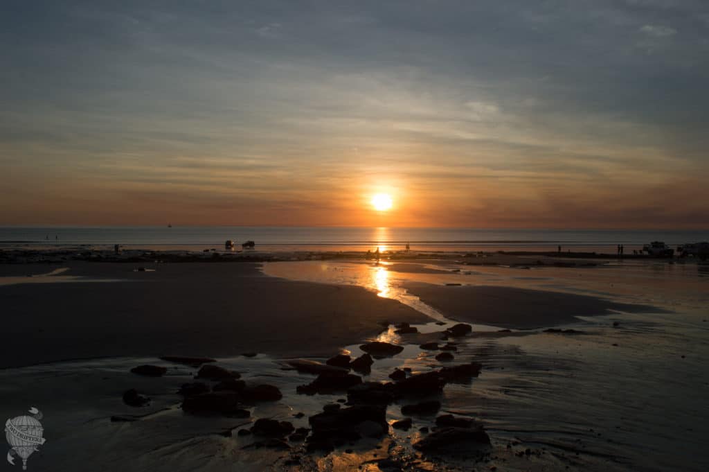 The sun sets over a beach.