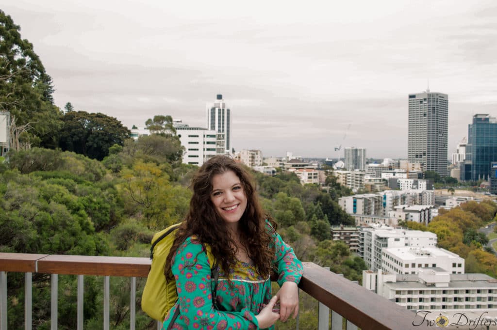 A woman smiles with a city skyline behind her.
