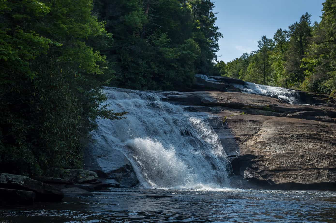 A waterfall cascades down rocks in the forest.