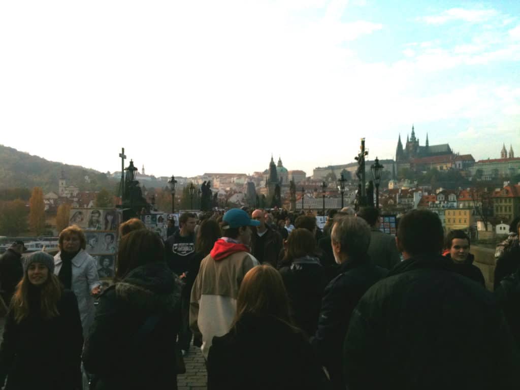 A group of people standing and walking around a plaza.