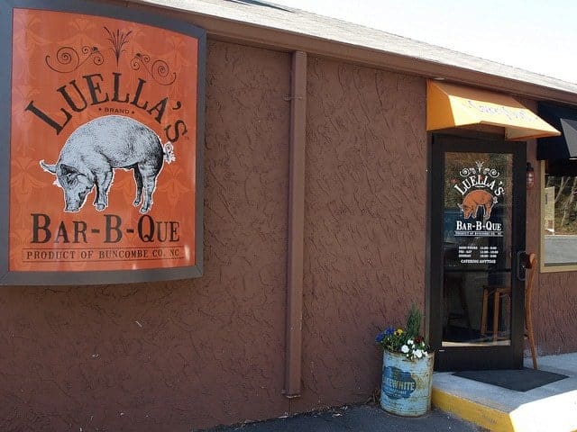 A red sign hangs on the wall that say\'s Luella\'s Bar-b-que.