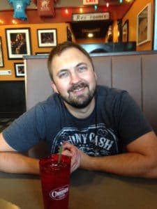 A man sitting at a table smiling.