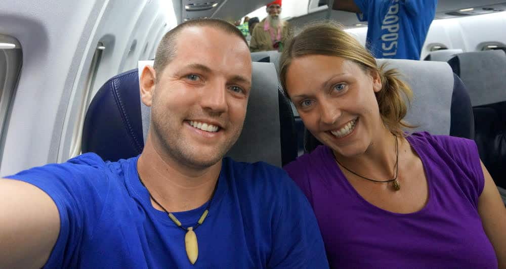 Man and woman sitting in an airplane smiling.