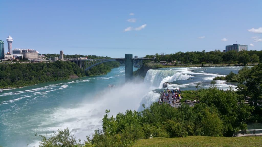 Big waterfall crashes down into a larger body of water.