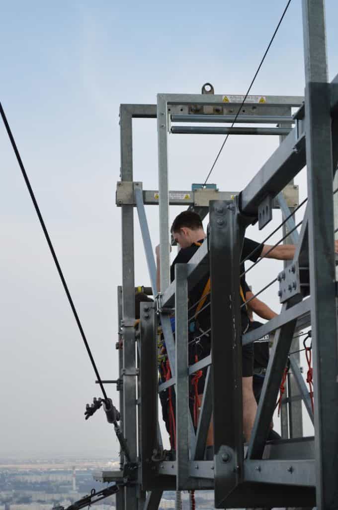 People stand on a metal piece getting ready to jump.