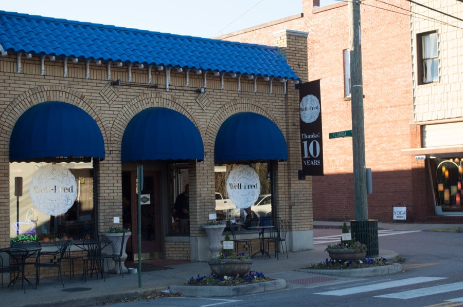 Exterior of a brick building with blue awnings.