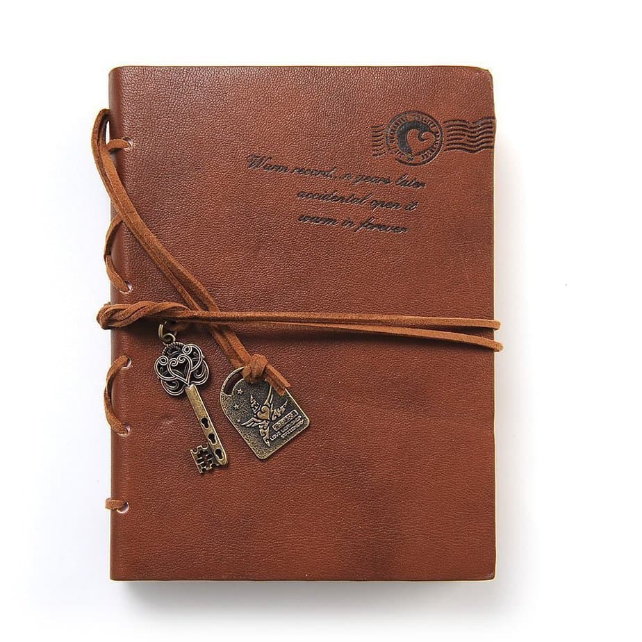 A brown leatherbound journal with a key charm.