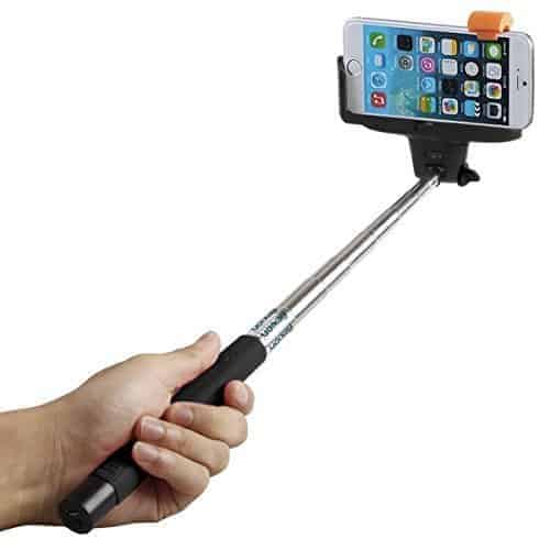 A man holds a selfie stick with a phone in it.