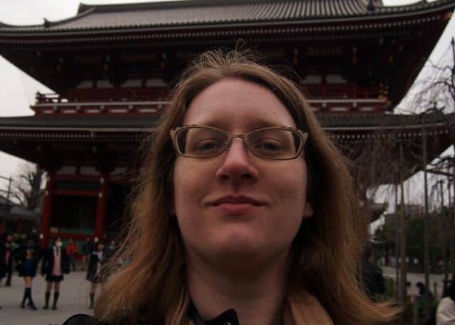 A woman wearing glasses smiling at the camera