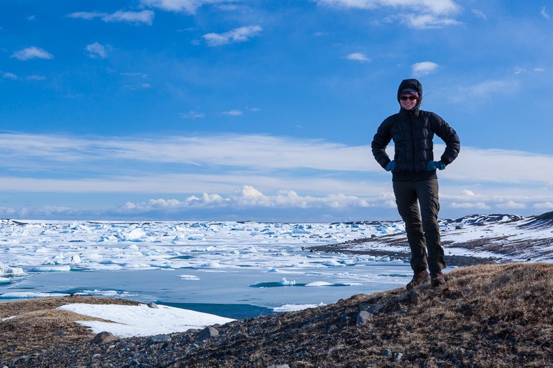 A man standing on top of a mountain surrounded by snow