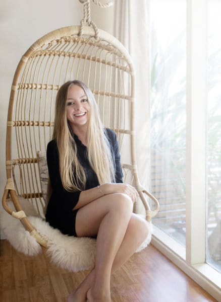 A woman sits in a seat near the window.