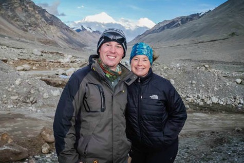 A man and woman standing in front of a mountain