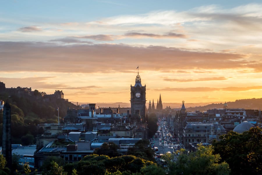 The sun sets over a city skyline.