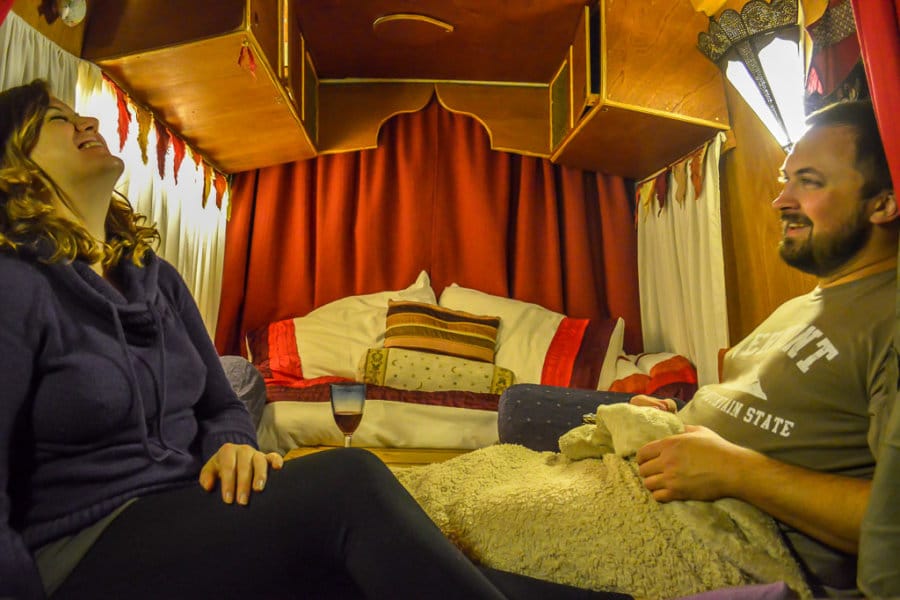 A couple laughs in a campervan bed