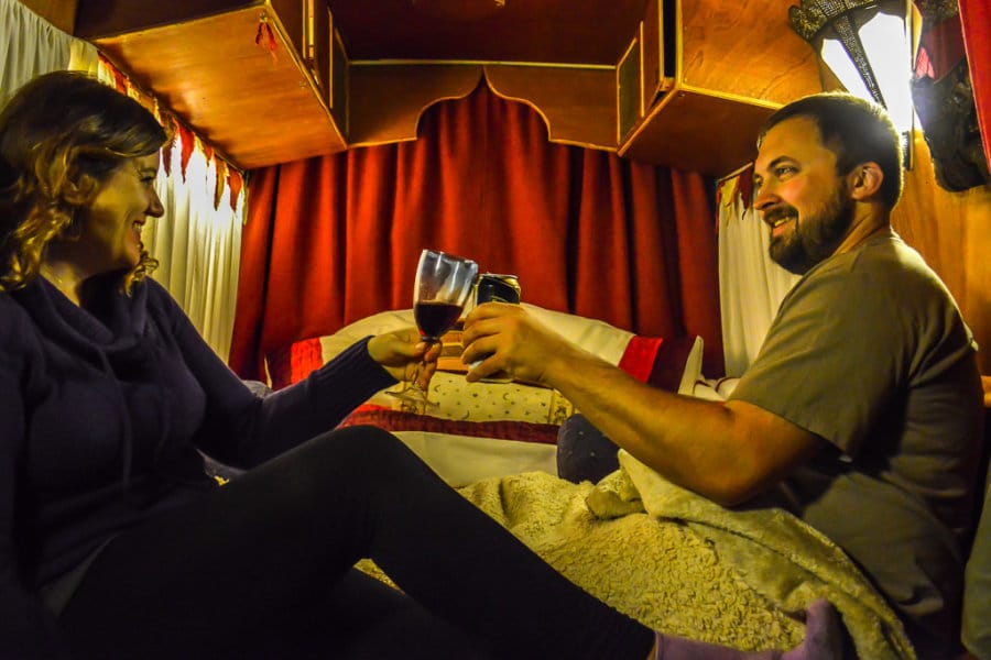 A couple toasts with wine while sitting in bed
