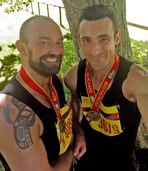 A couple smiles while wearing medals.