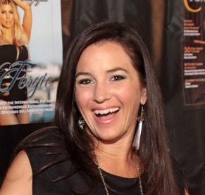 A woman with brunette hair smiles.