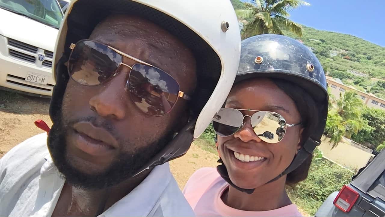 A couple in helmets smiles at the camera.