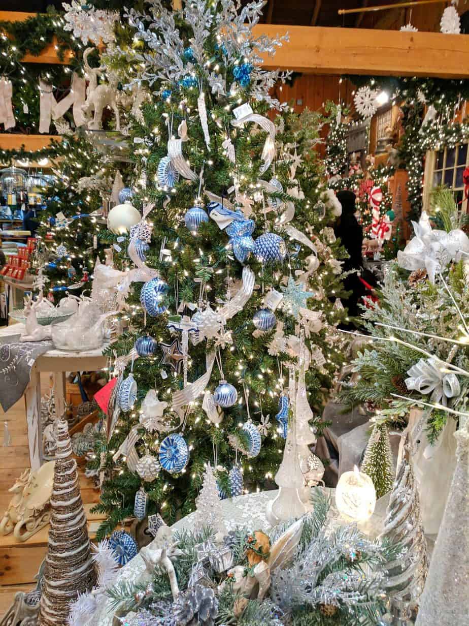 A Christmas tree is beautifully decorated with blue and white ornaments.