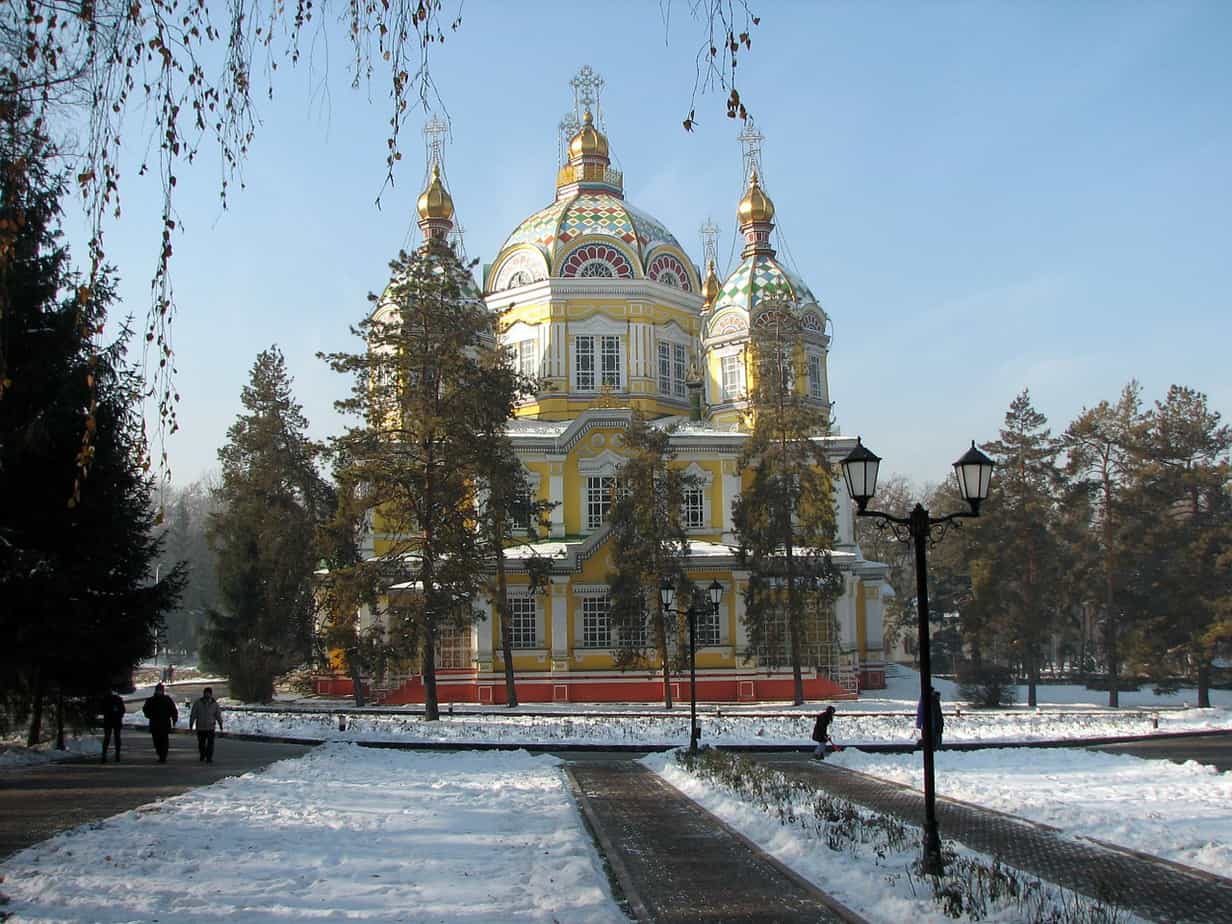 Yellow building with dramatic architecture under a blue sky covered in snow.