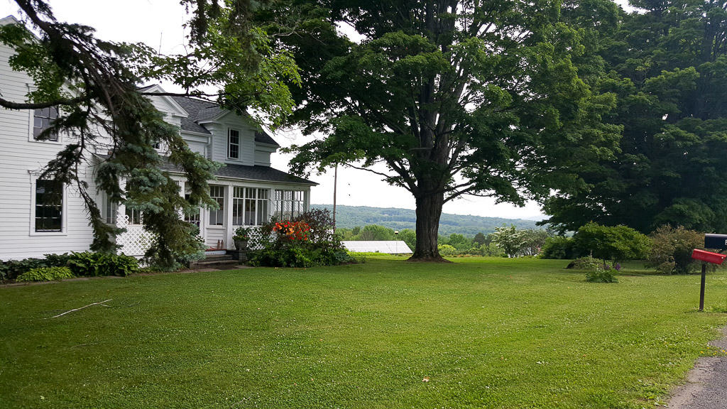 A white house with a grassy lawn in front of it.