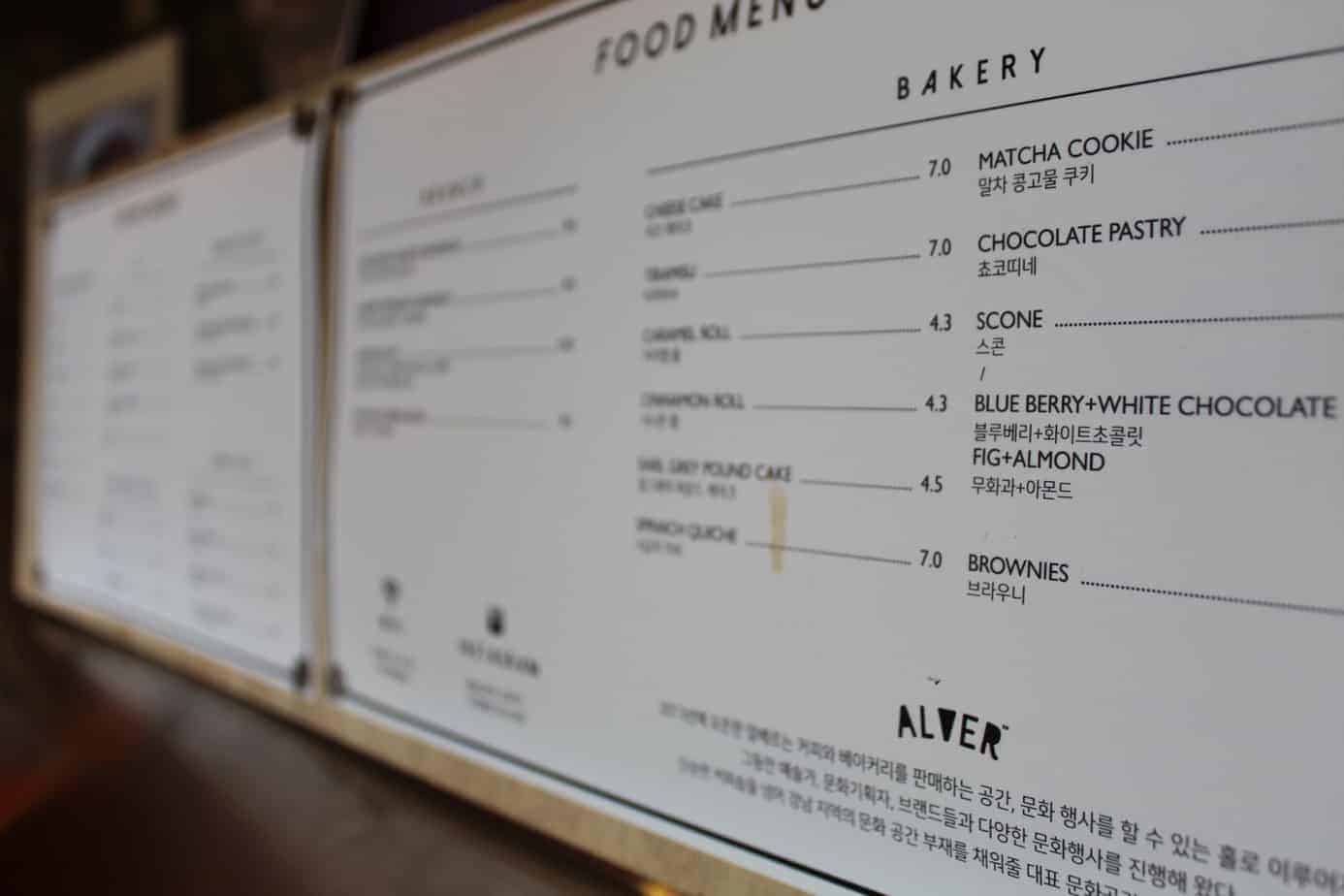Close up of a white cafe menu on the wall.