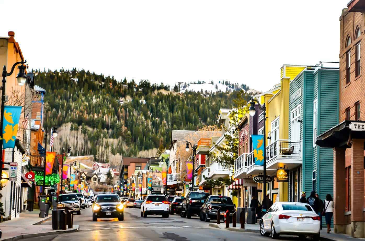 A busy downtown street in front of mountains.