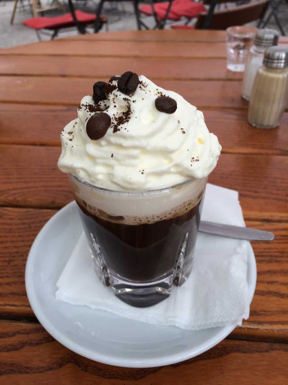 Close up of a chocolate drink with whipped cream and beans.