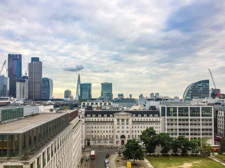 View from the top of a large building overlooking a city on a cloudy day. 