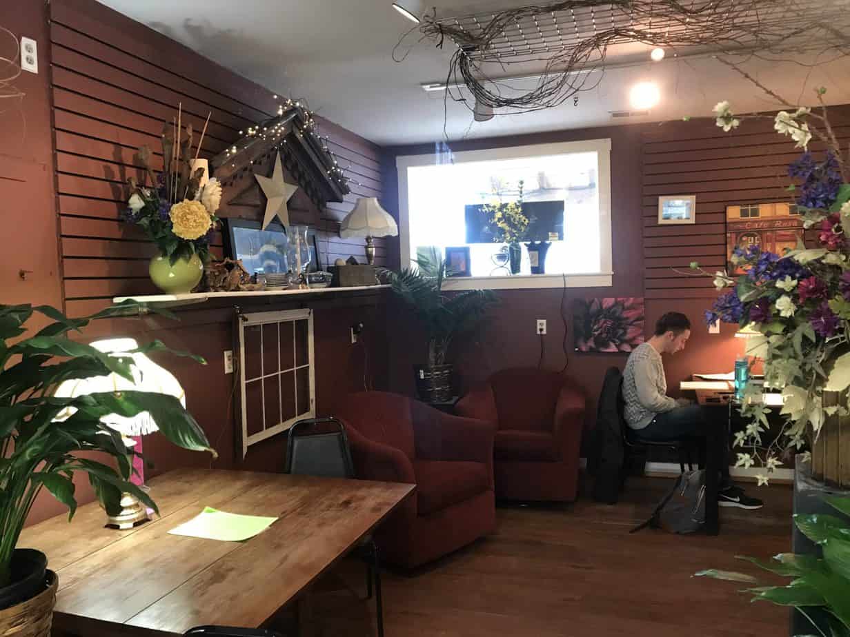 People sit and relax at a table with red walls.