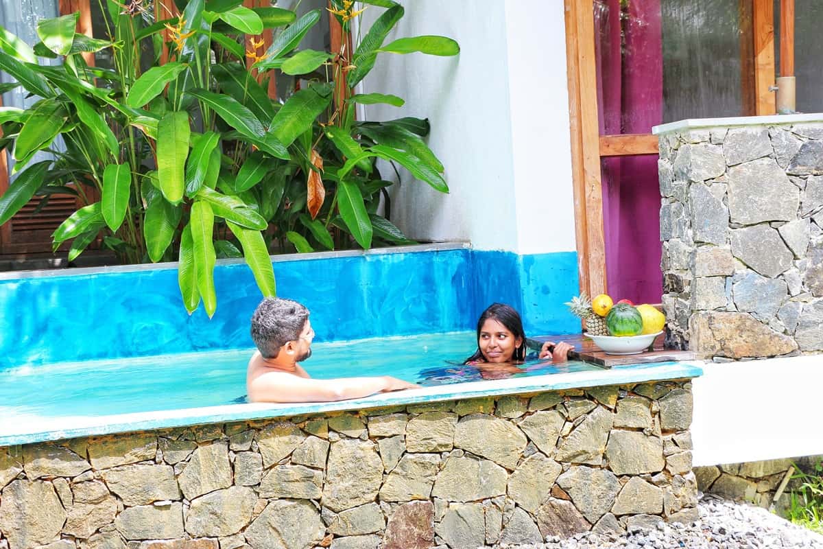 A couple sits in a pool outdoors