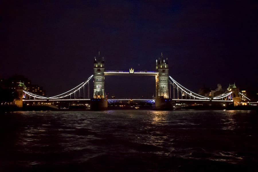 View of the Tower Bridge in London lit up at night. 