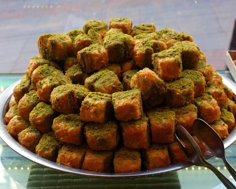 Close up of baklava stacked high on a plate.