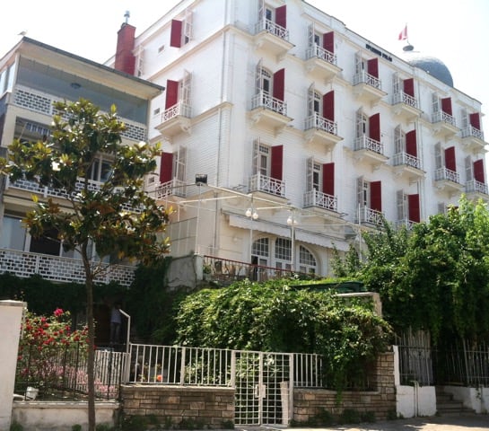 Outside of a white building with red shutters.