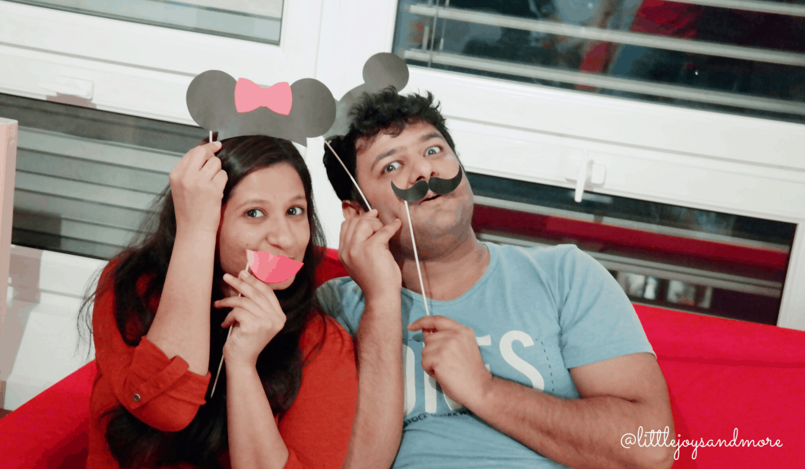 Man and woman making funny faces while holding props.