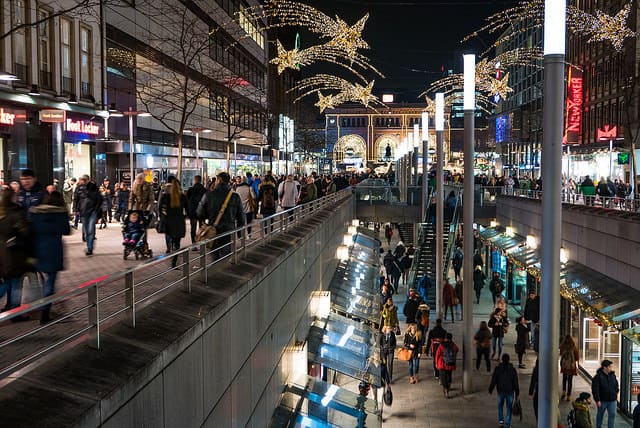 People shopping in a two-floor shopping center at night.