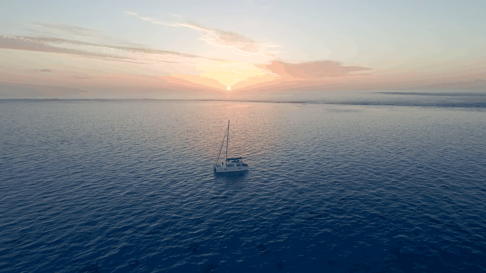 A small boat in a large body of water at sunset.