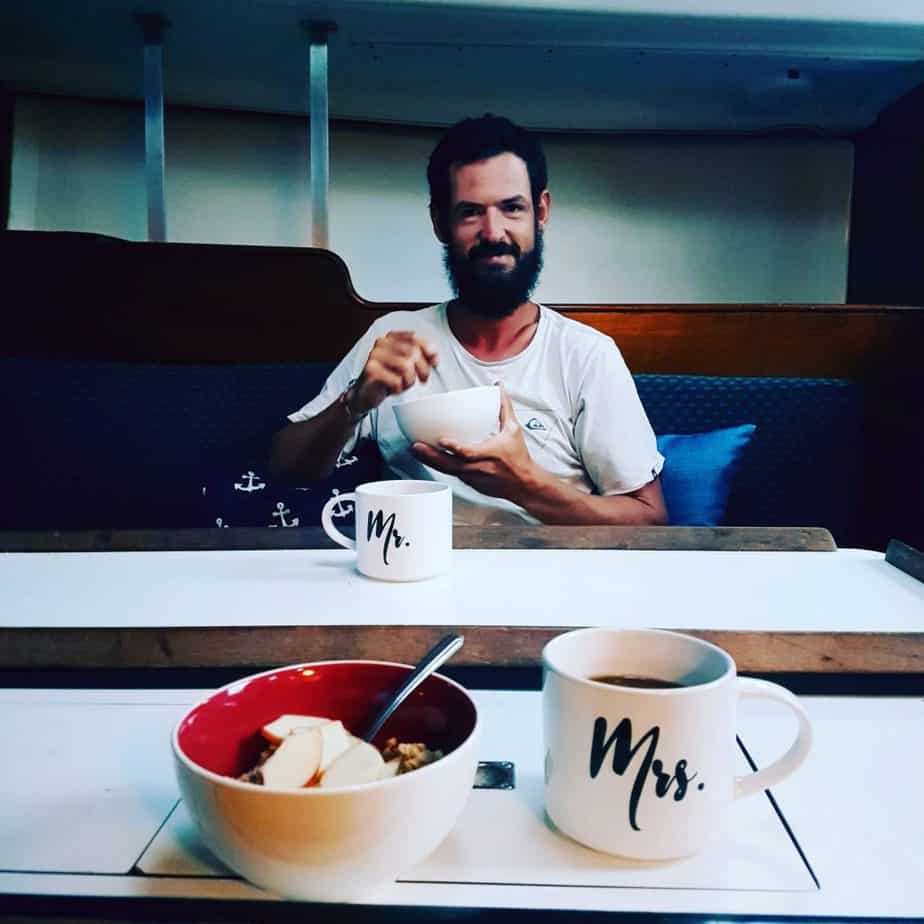 A man eats breakfast on a table.