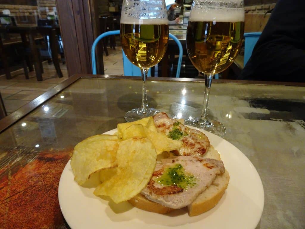 Close up of a plate of food. Two glasses of wine stand behind it.