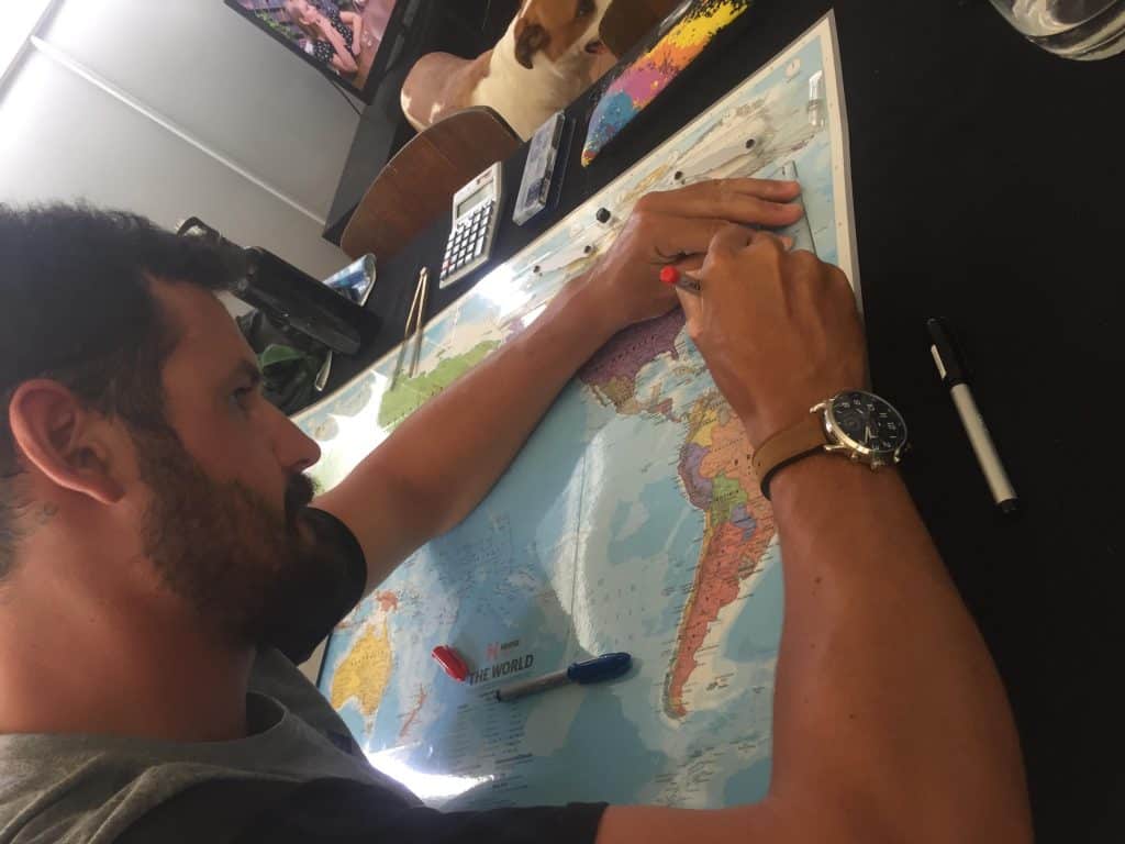 A man looks at a map and marks things with a pen.
