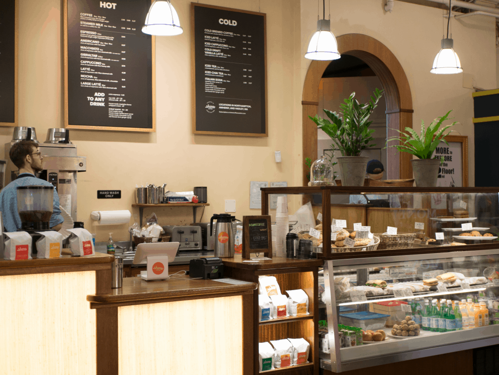 A barista works behind a counter at a cafe.