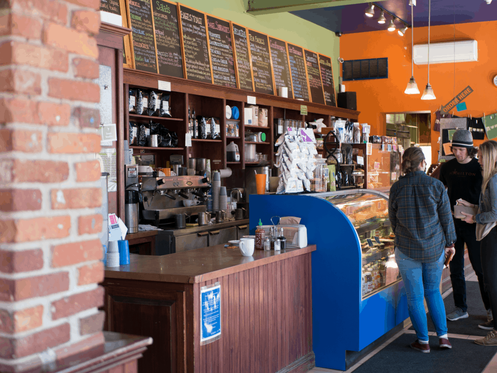 People stand in line to order food at a cafe.