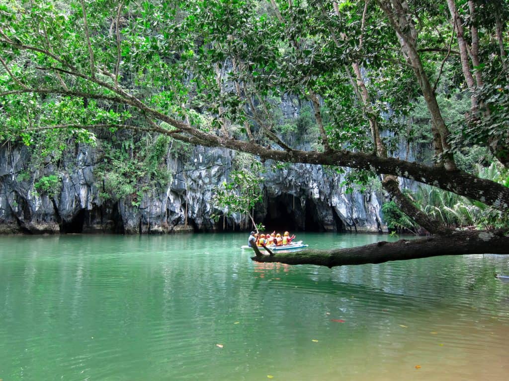 People are on a boat heading into a cave.