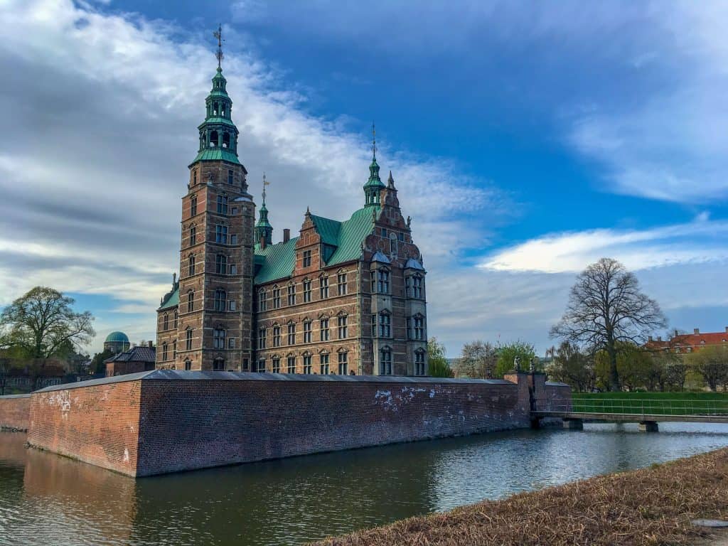 Big church surrounded by a brick fort near the water.