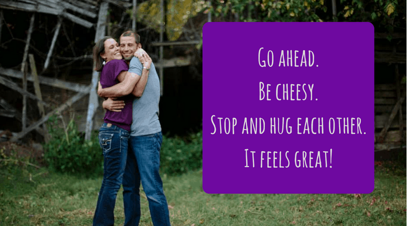 A couple hugs with text next to them that says \"Go ahead. Be cheesy. Stop and hug each other. It feels great!\"